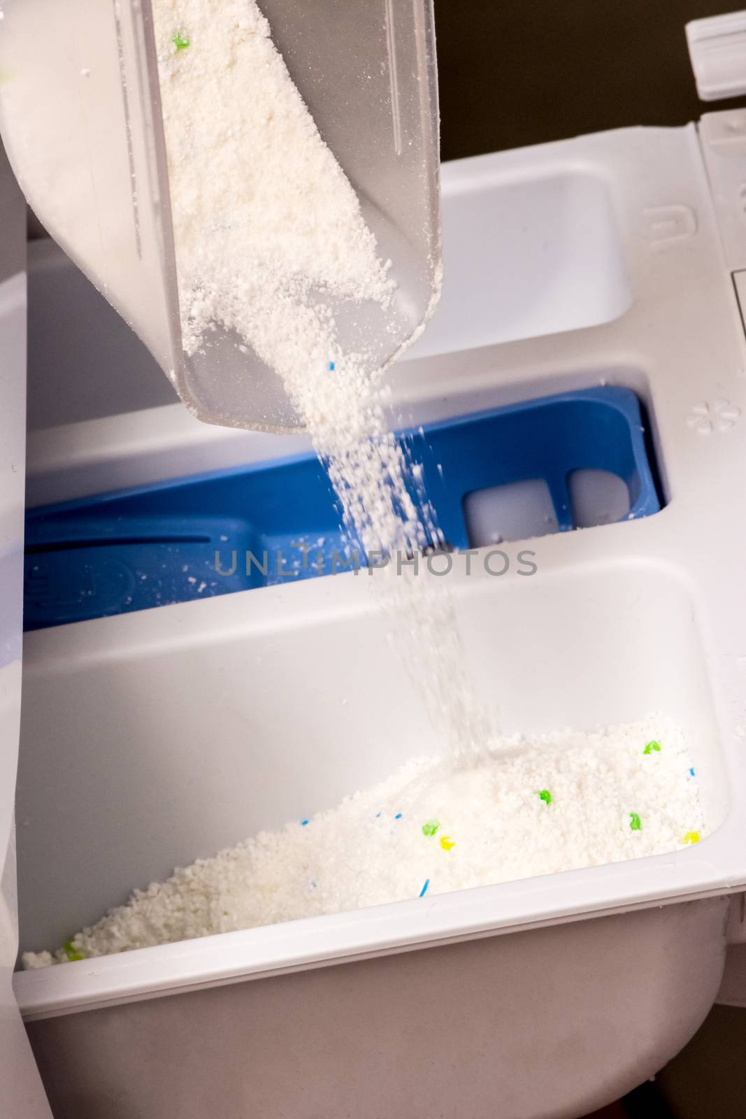 women is pouring powder detergent in wesh machine to washing dirty clothes