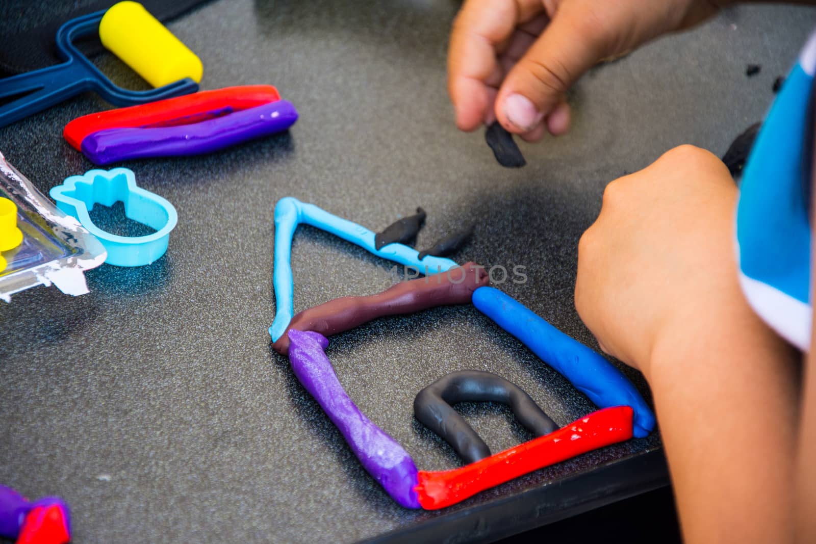 children playing with modeling clay of different colors in the school