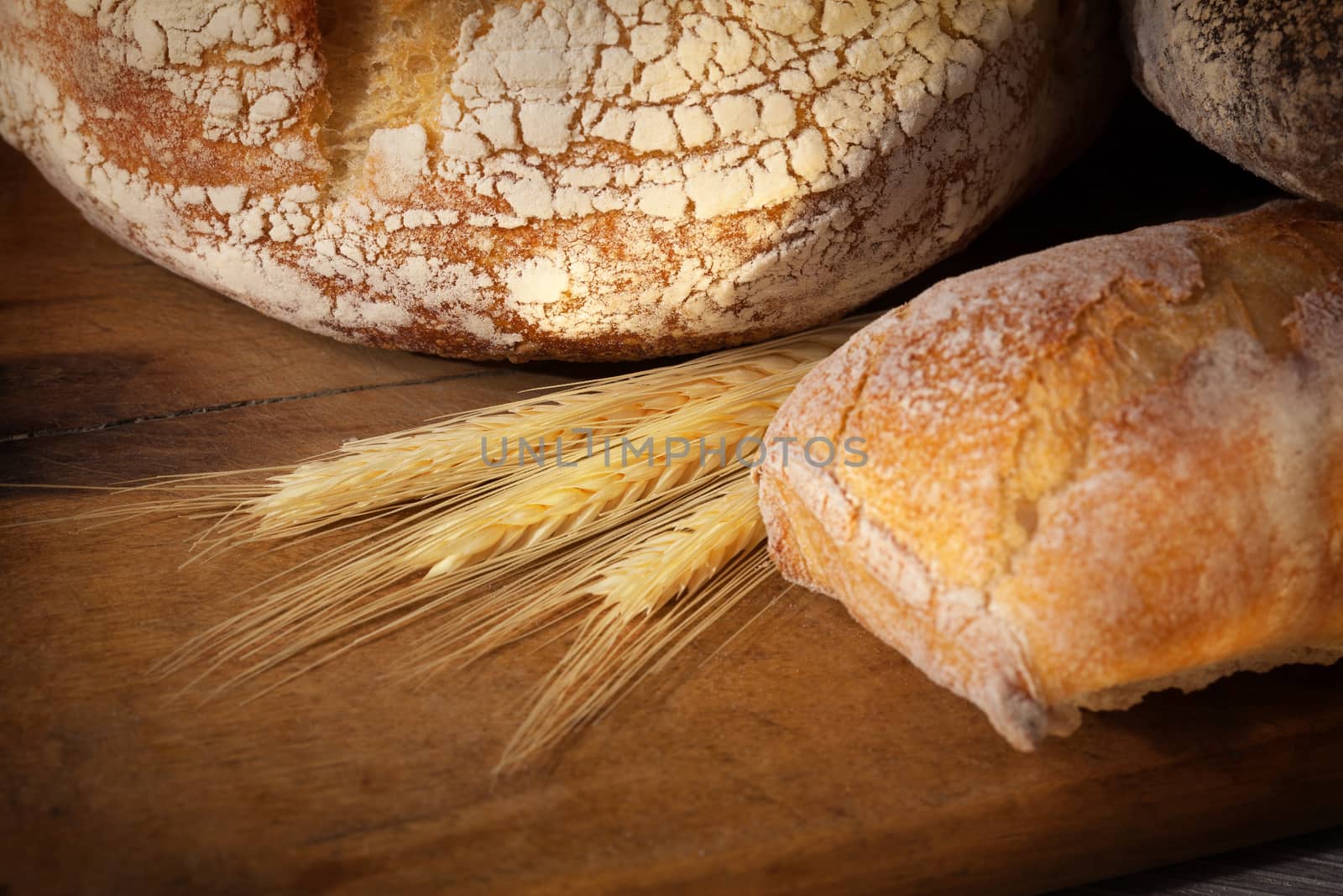 Crannied rustical homemade bread on old cutting board. Different types of bread.