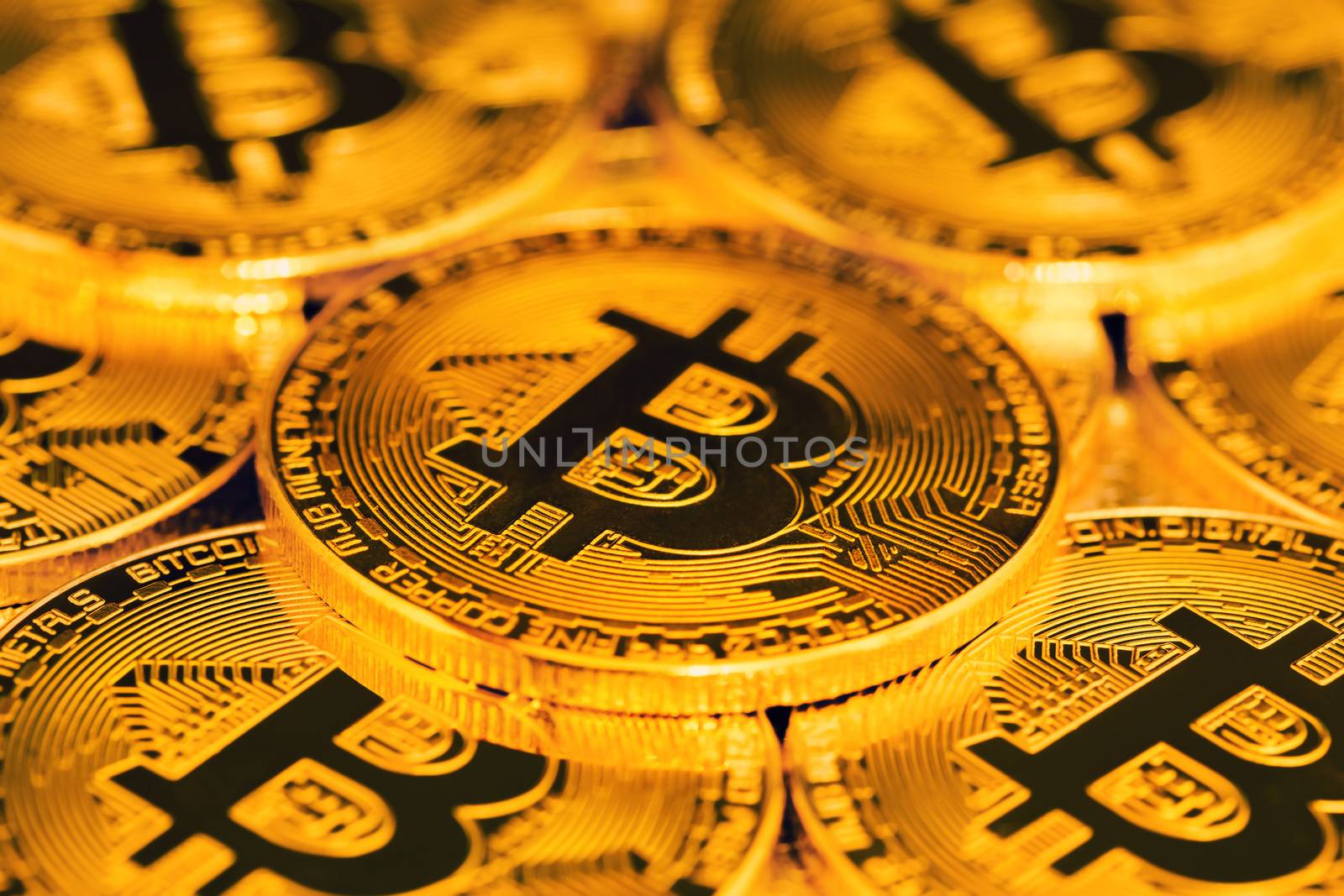 close up of pile of golden bitcoins in backlight