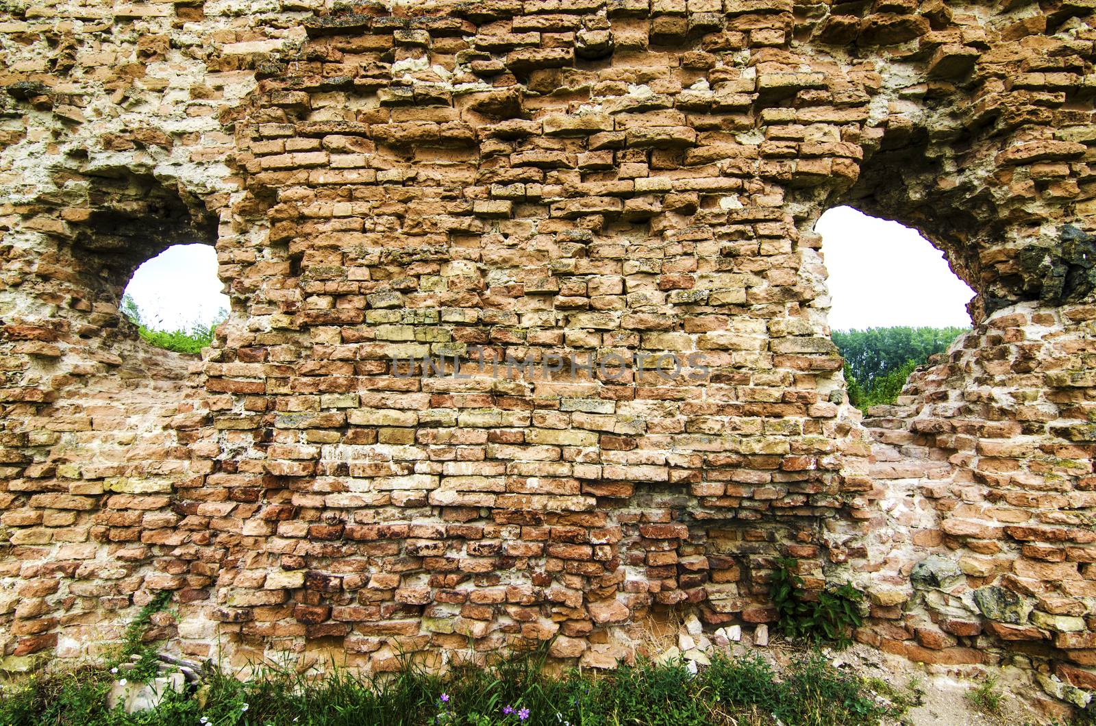 Old damaged brick castle on cloudy day