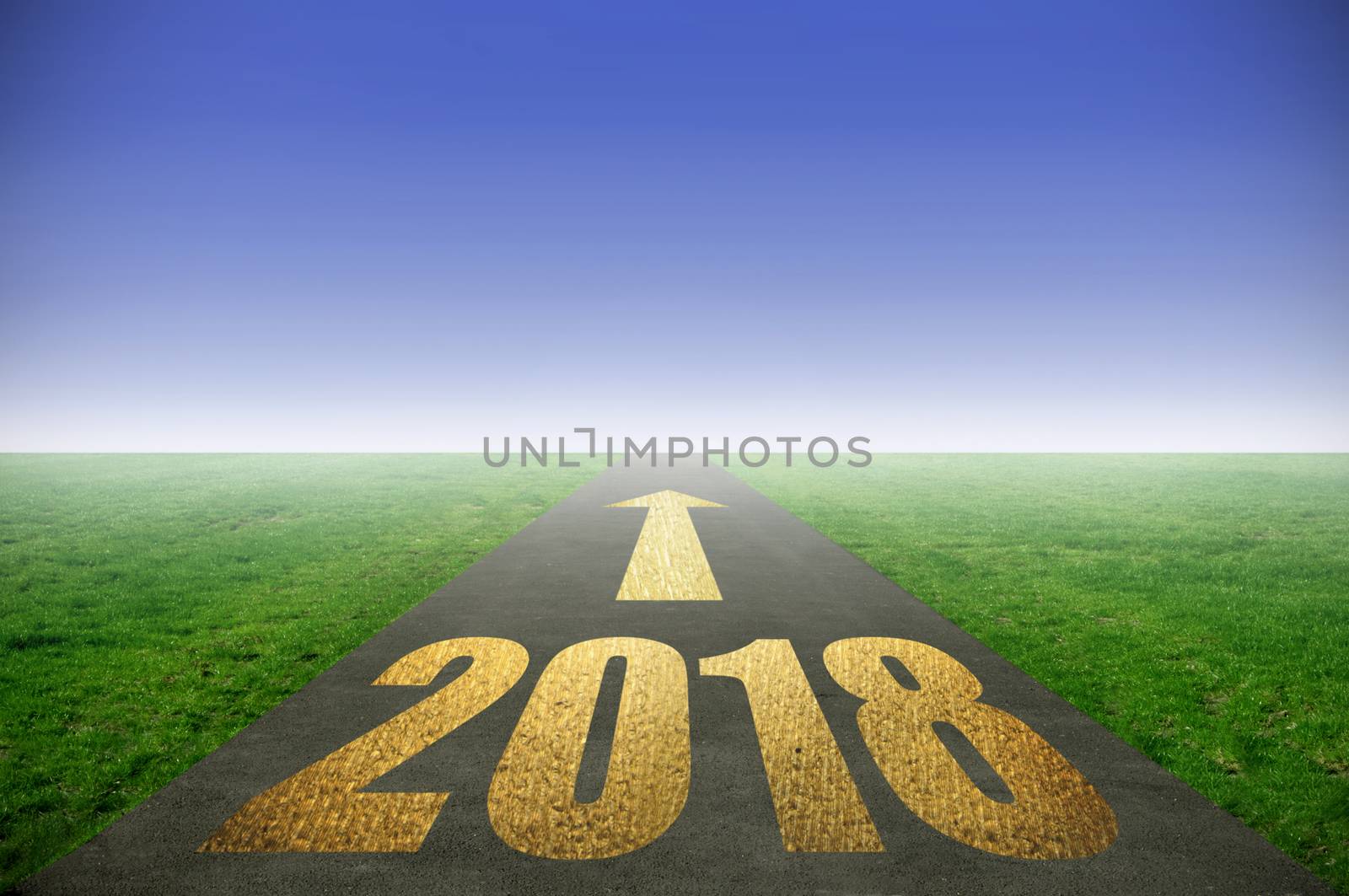 2018 printed in gold on road with green grass on each side