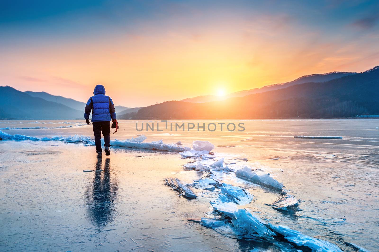 professional photographer with camera on frozen river in winter. South Korea in winter.