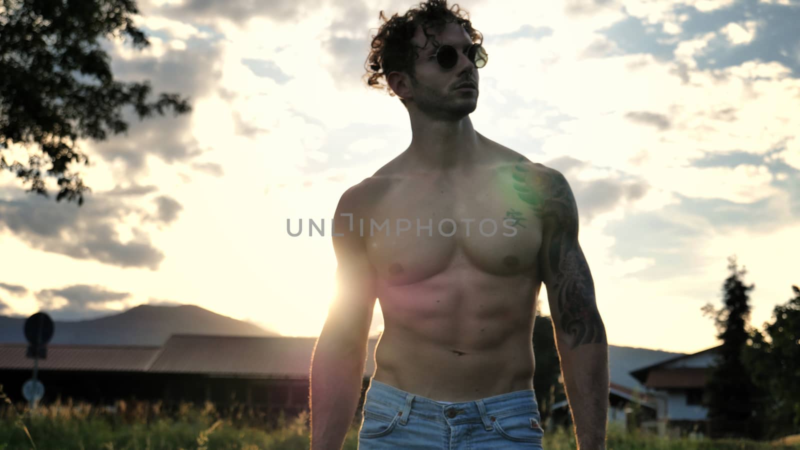 Handsome Muscular Shirtless Hunk Man Outdoor in Country Standing on Grass. Showing Healthy Muscle Body While Looking away