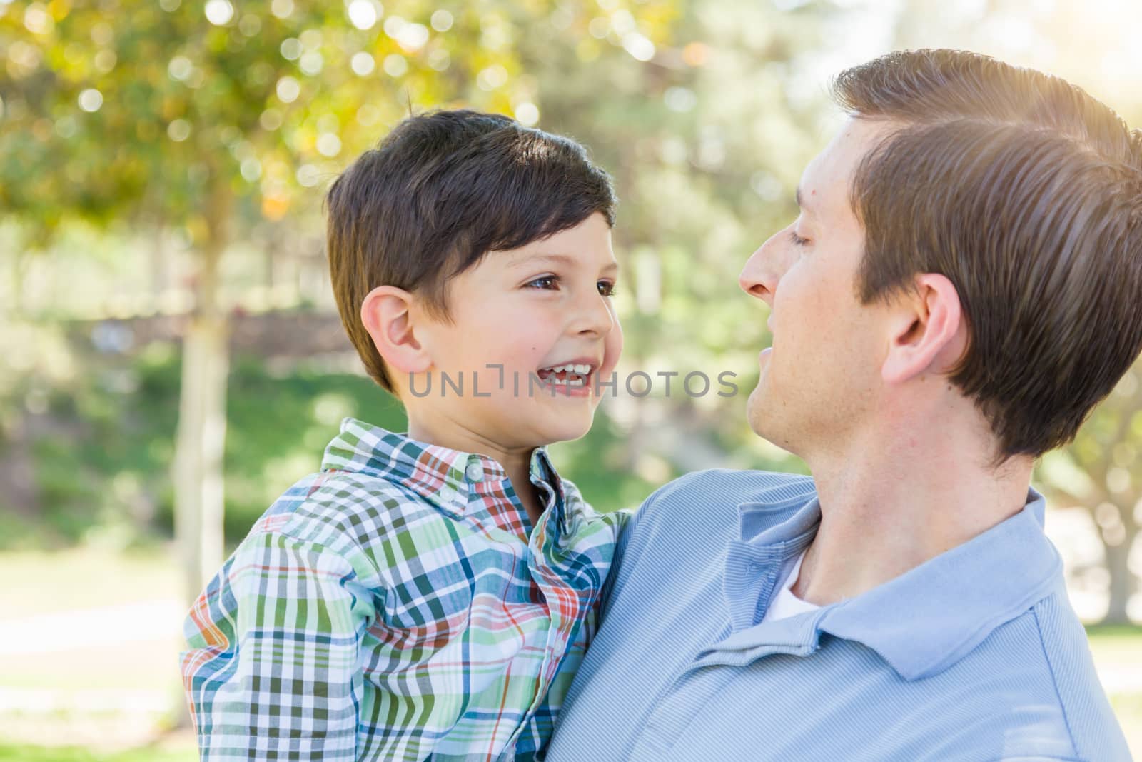 Happy Caucasian Father and Son Playing Together in the Park.