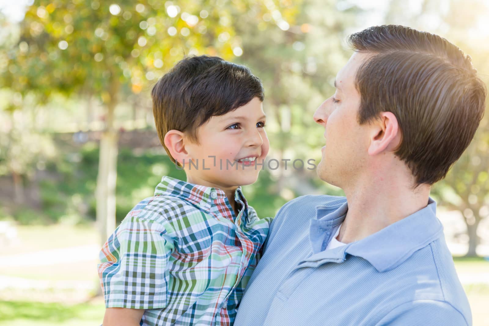 Happy Caucasian Father and Son Playing Together in the Park. by Feverpitched