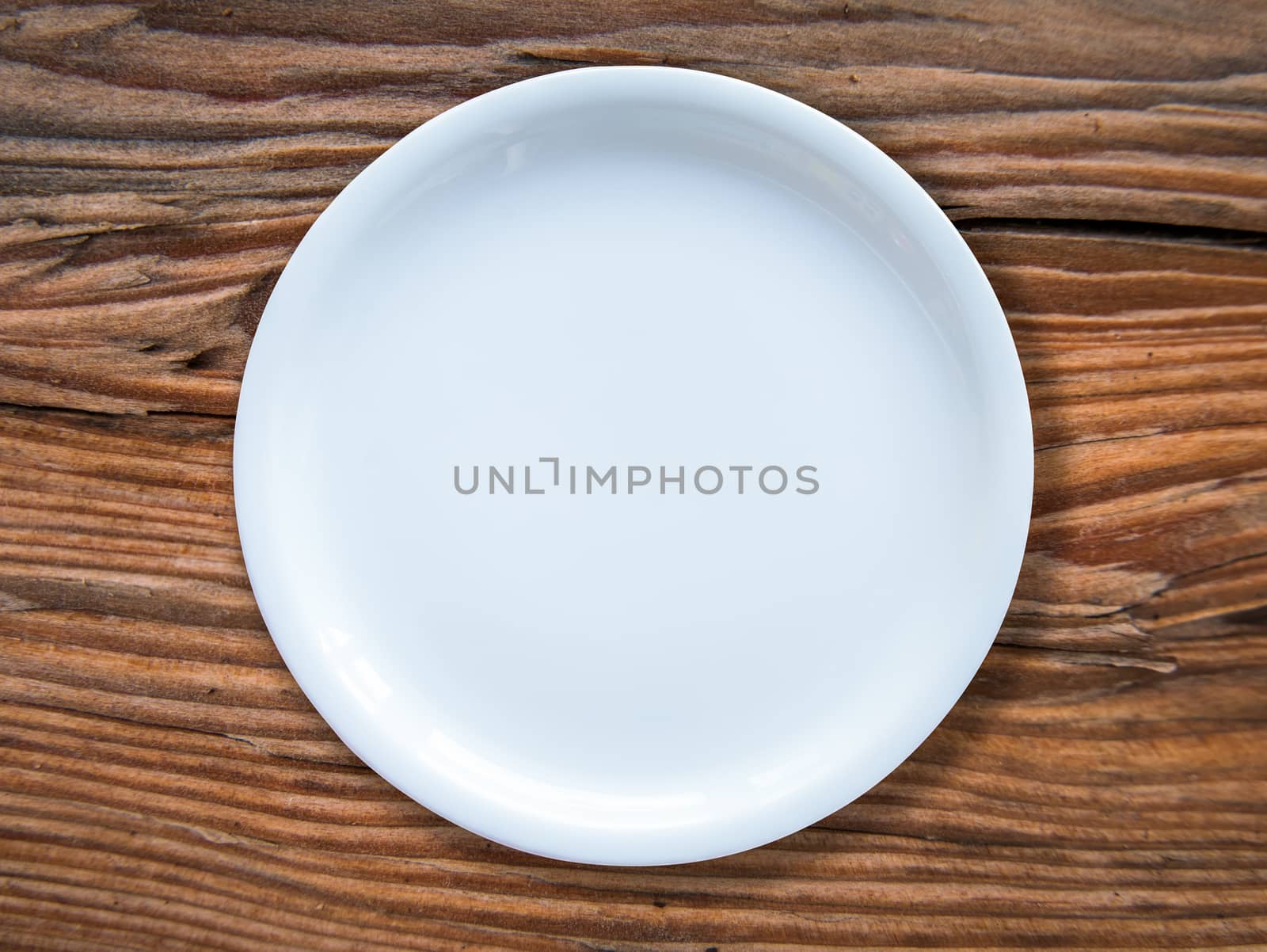 An Empty White Plate On A Rustic Wooden Table