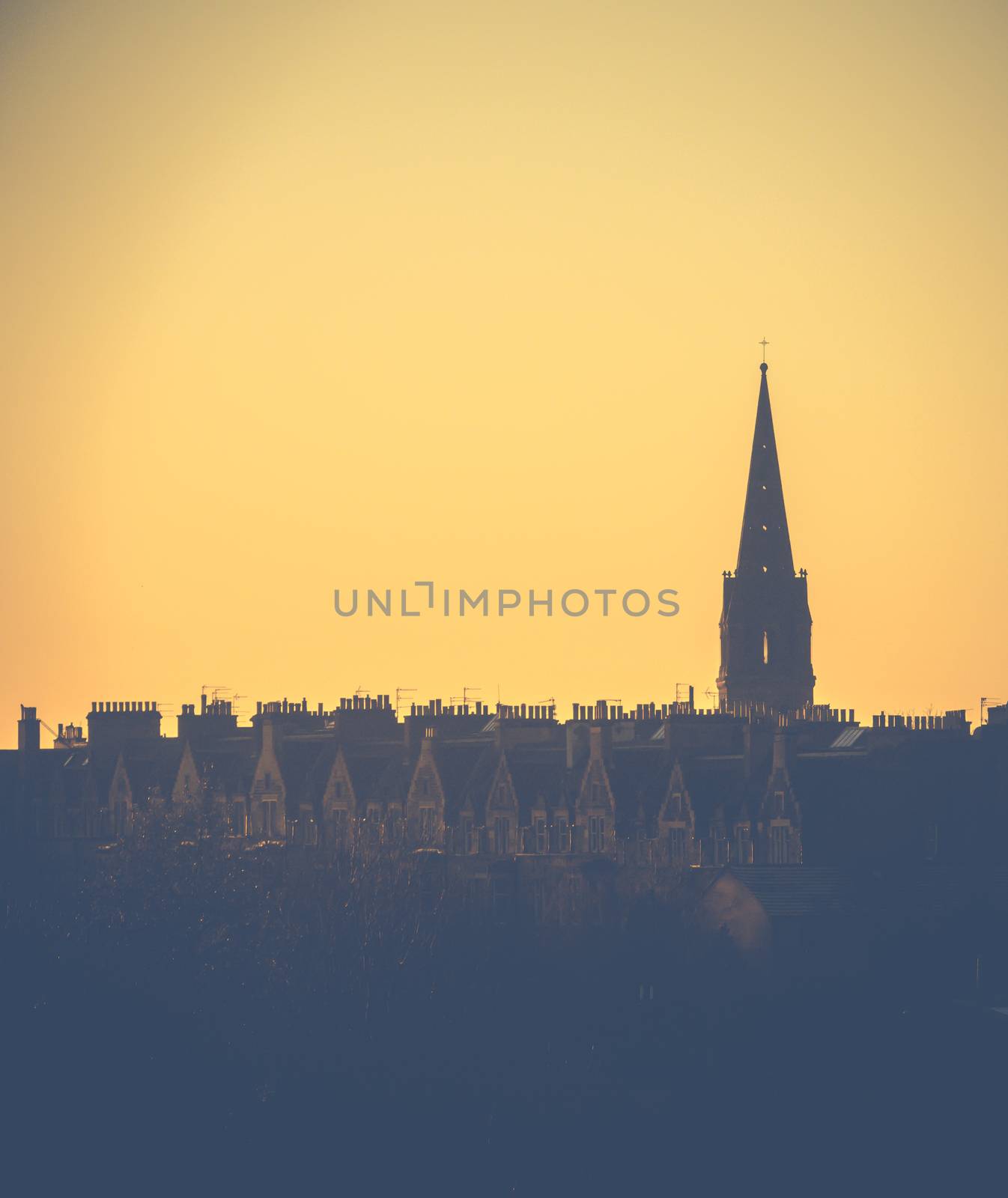 Retro Style Image Of A Row Of Edinburgh Tenement Apartments And Church Spire At Sunset