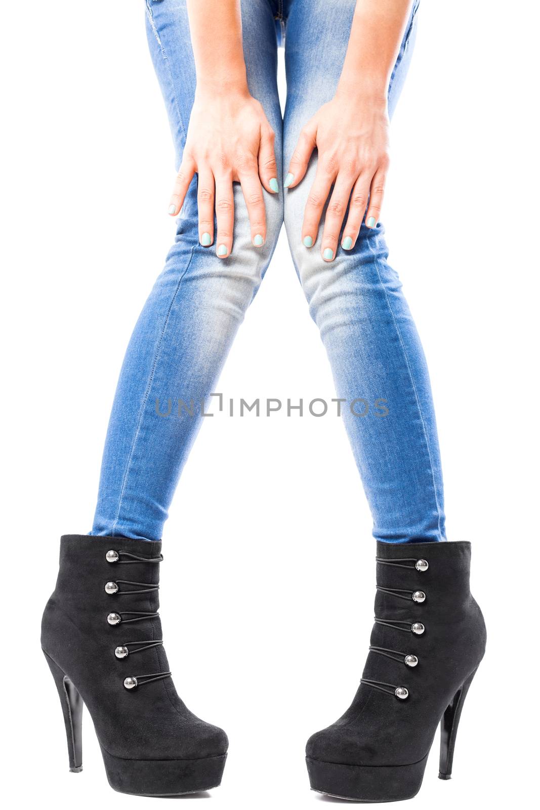 girl touching her legs in blue jeans and black high heels