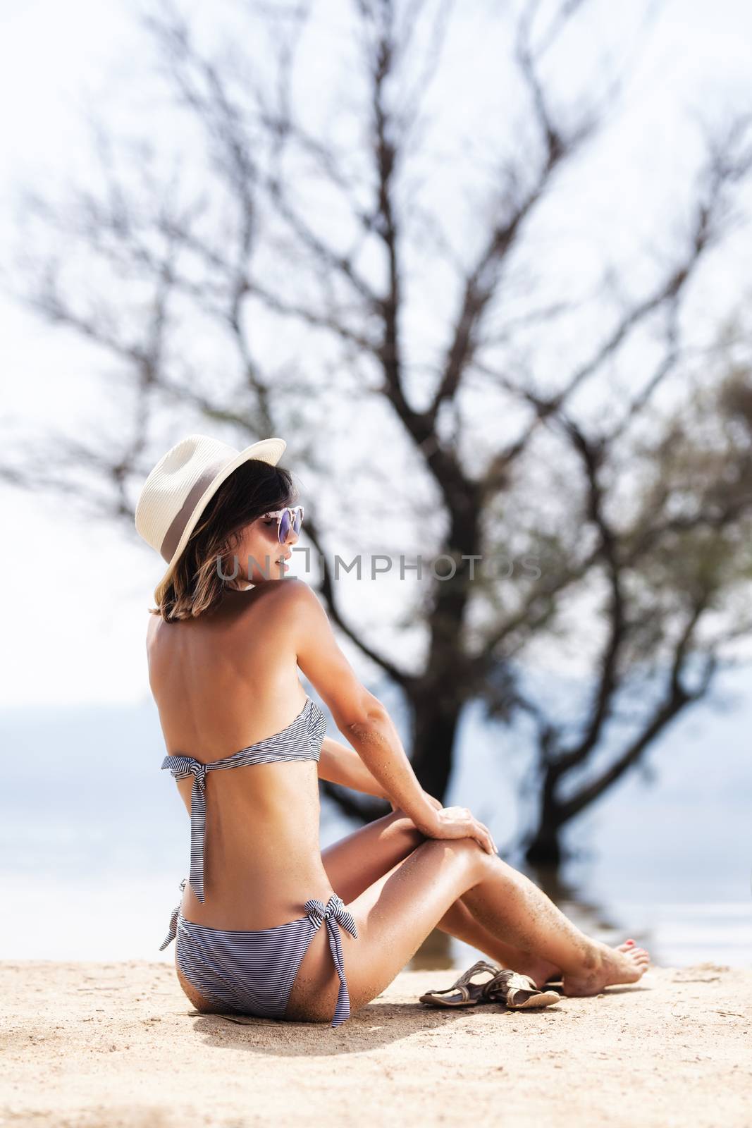 girl sunbathing on a beach by kokimk