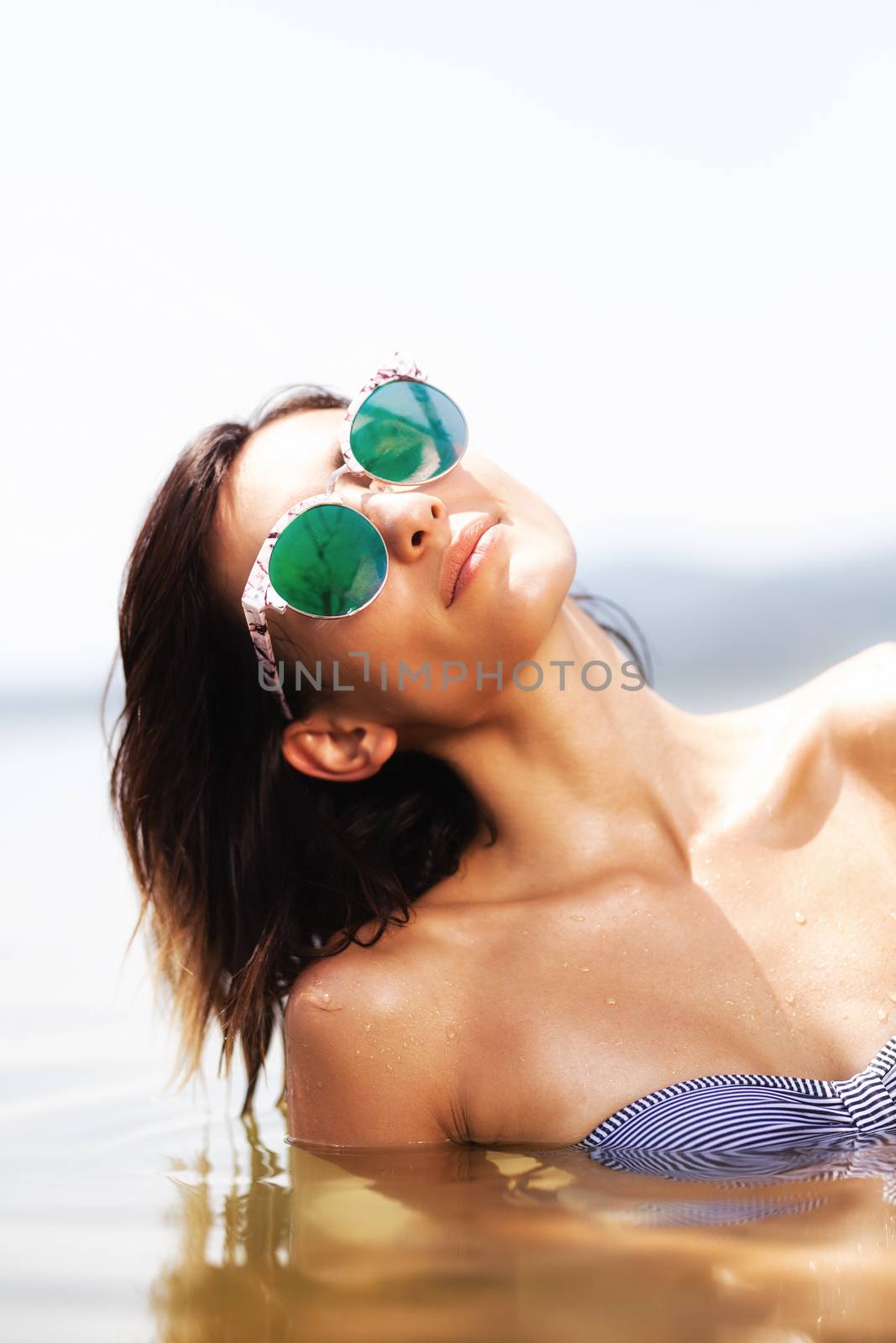 portrait of a sexy girl with sunglasses in water