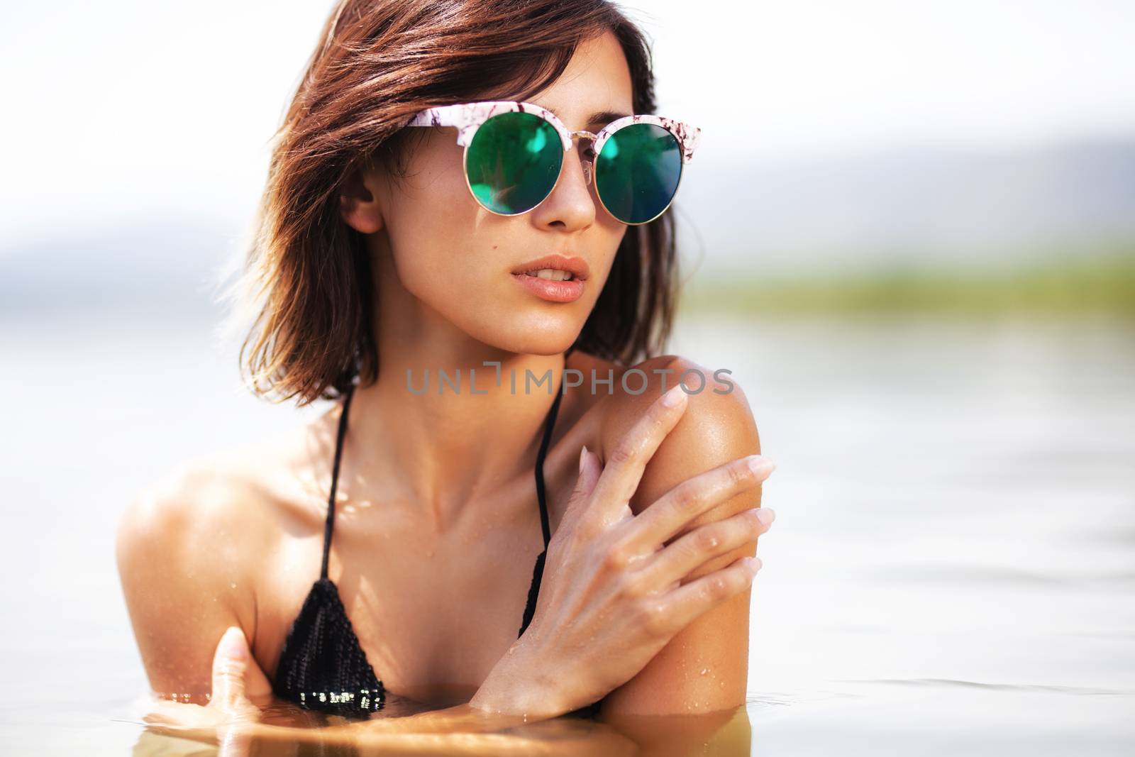 girl posing in water near a beach by kokimk