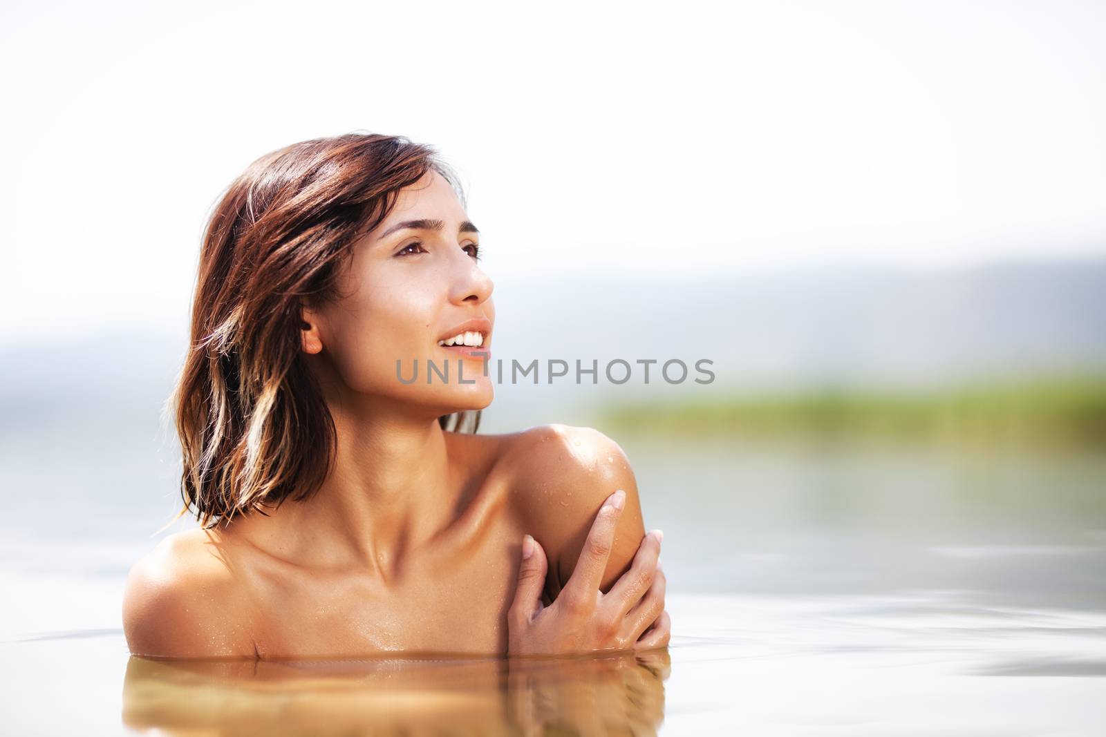 portrait of a sexy girl hugging herself in water