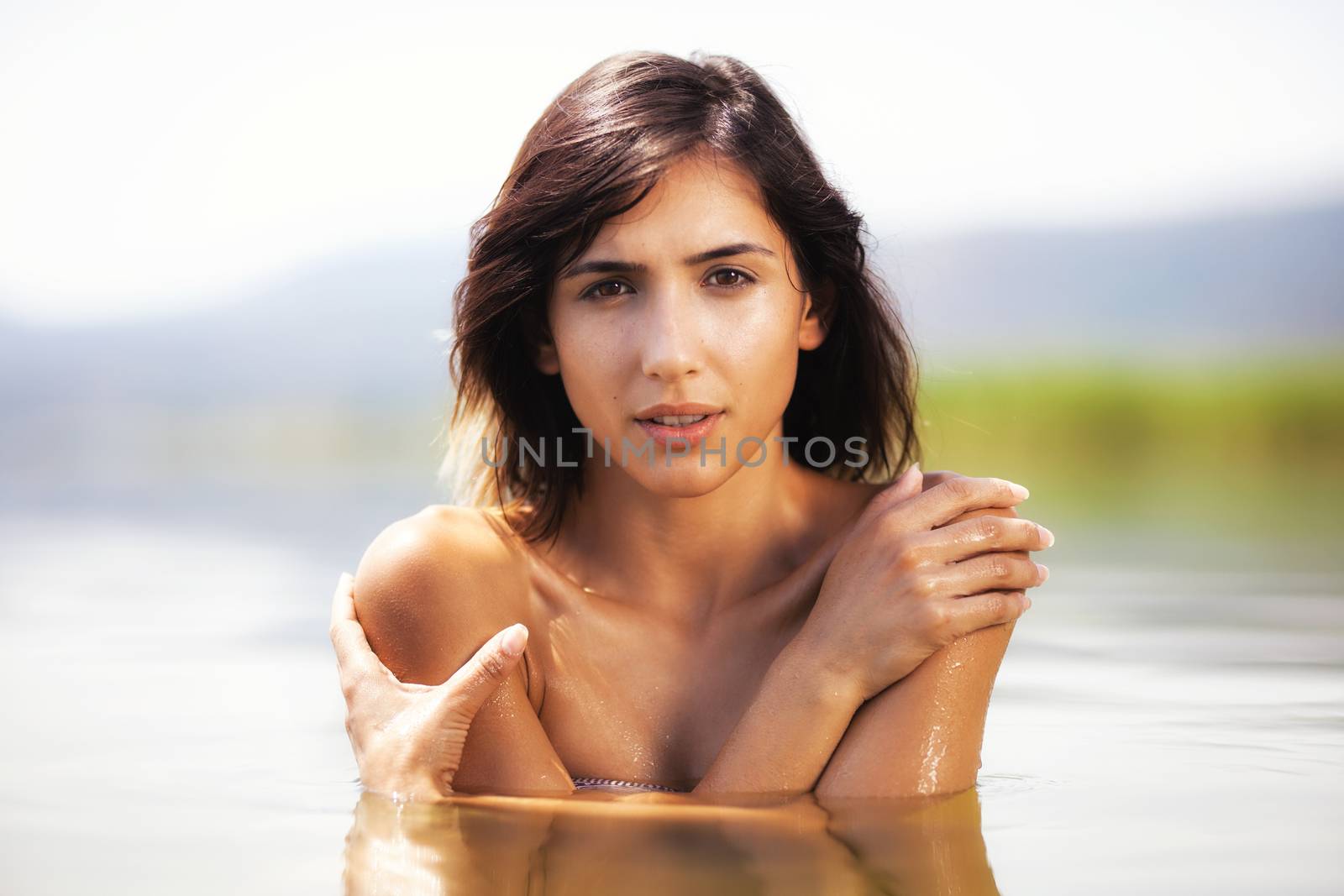 portrait of a sexy girl hugging herself in water