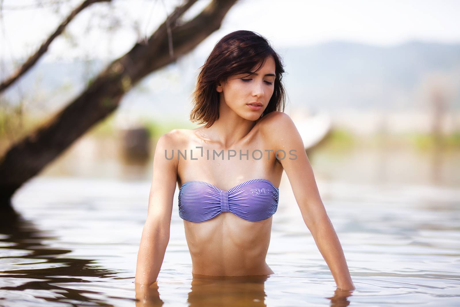 girl in water near a beach by kokimk