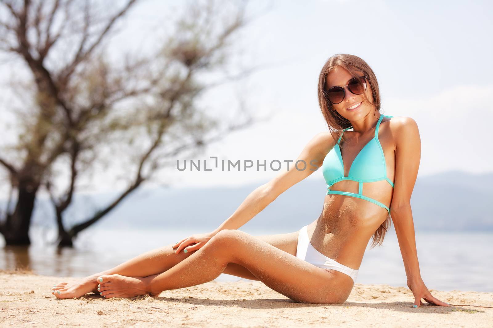 sexy girl with sunglasses sunbathing on a beach