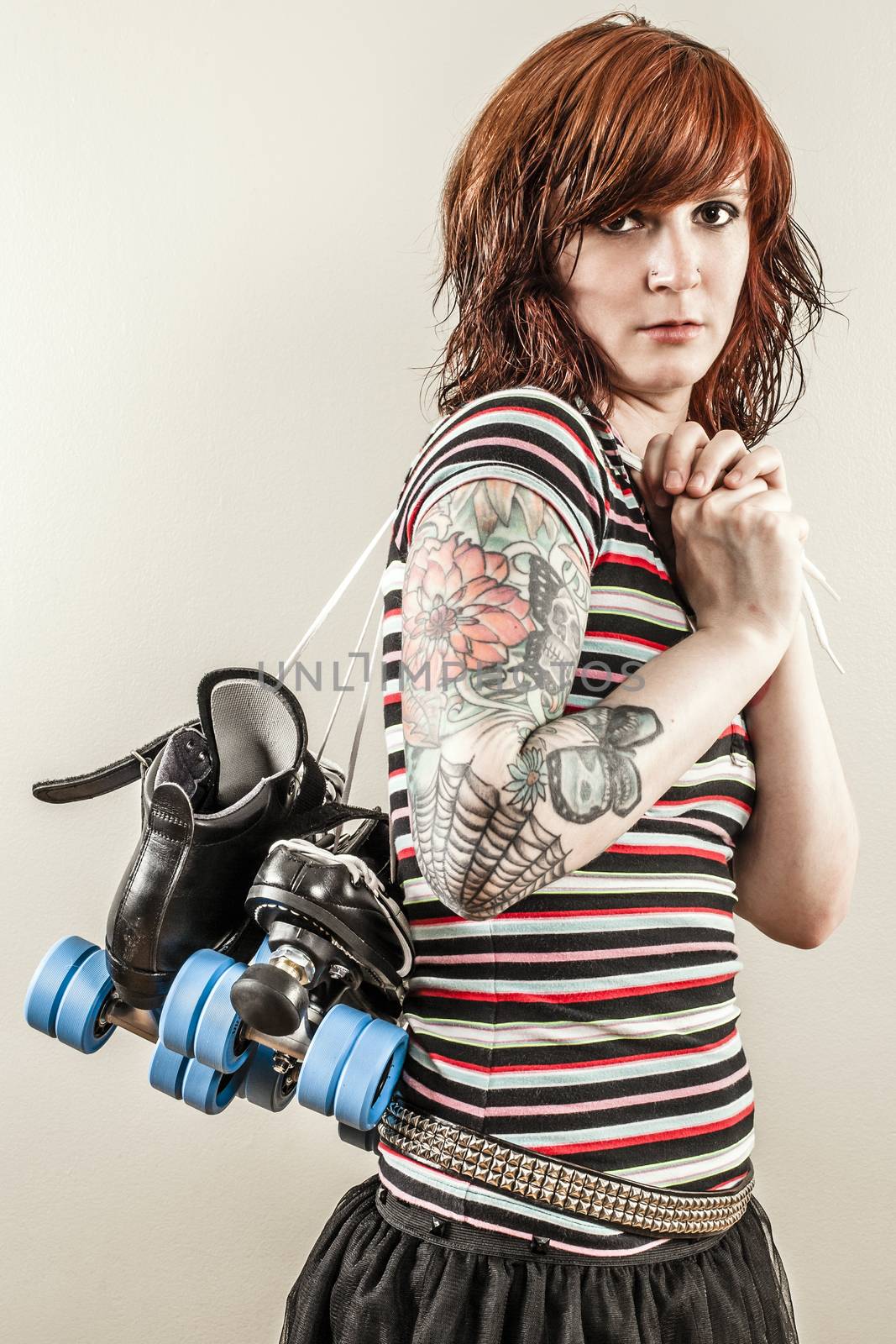 Photo of a roller derby girl holding her skates by the laces.