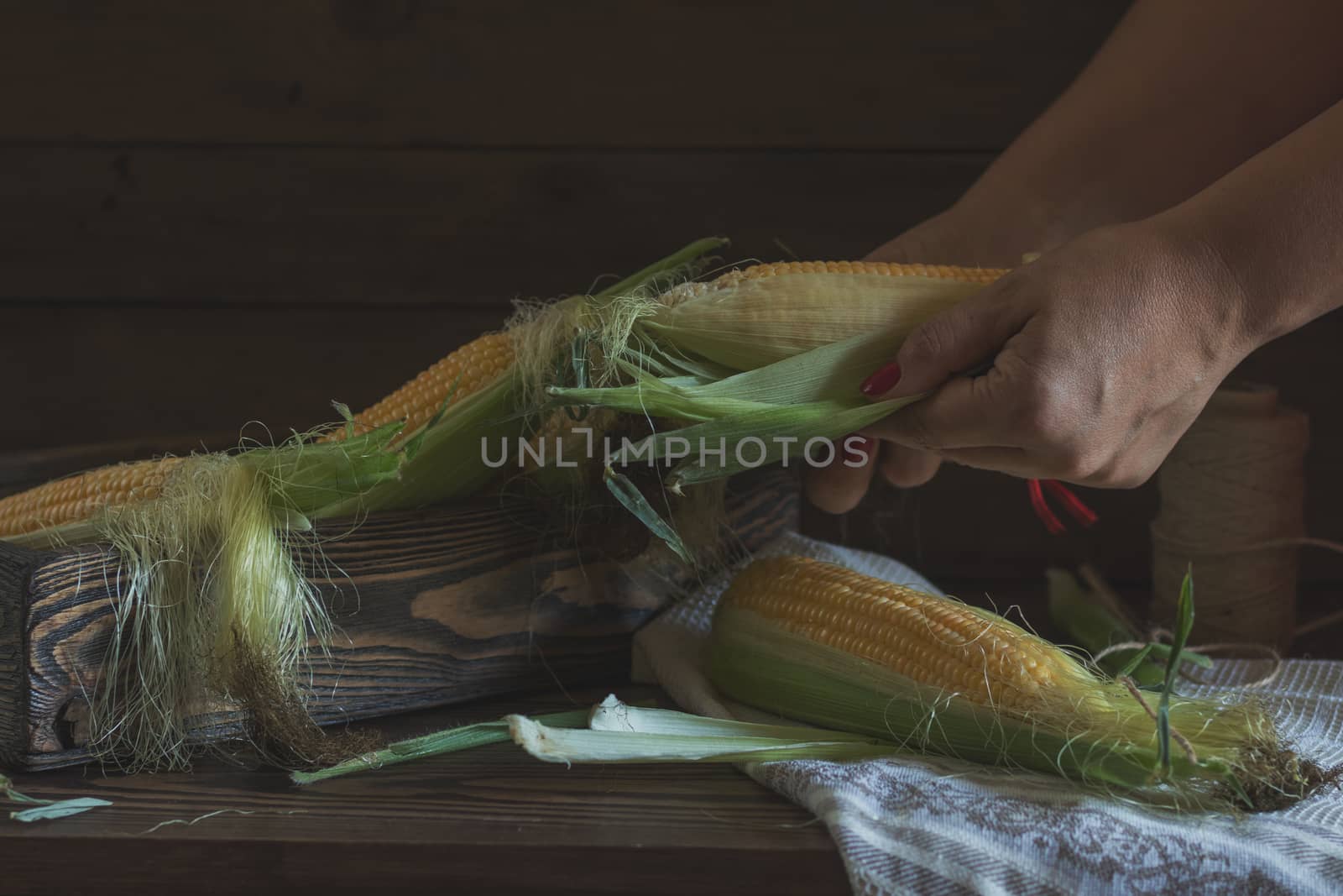 Fresh sweet corn on cobs on rustic wooden table, close up. Toned. Shallow depth of field.