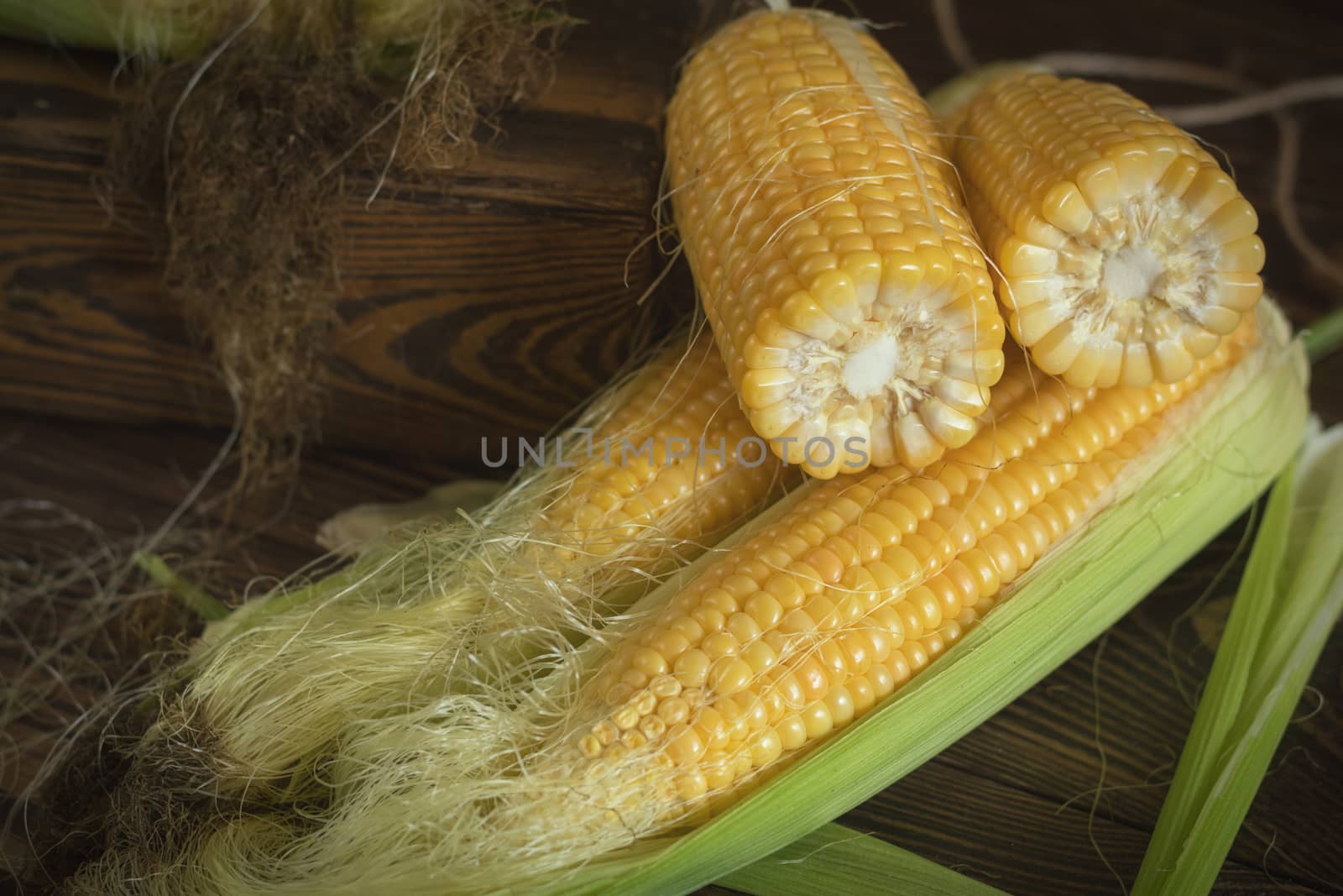 Fresh sweet corn on cobs on rustic wooden table by ArtSvitlyna