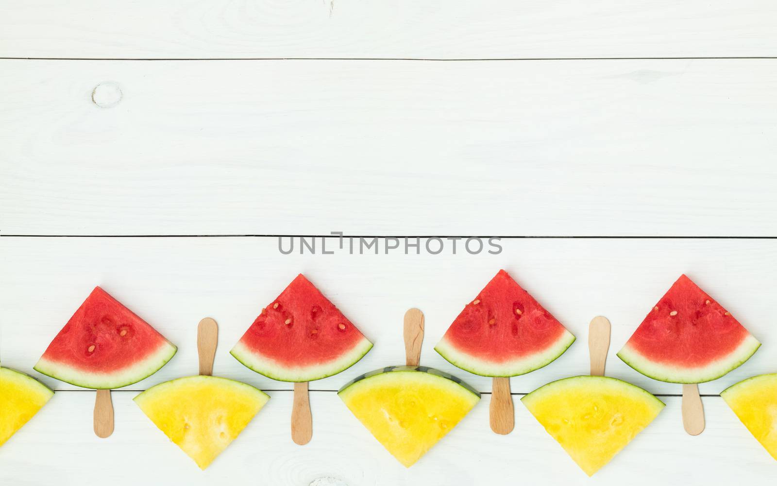Red and yellow watermelon slices on sticks by ArtSvitlyna
