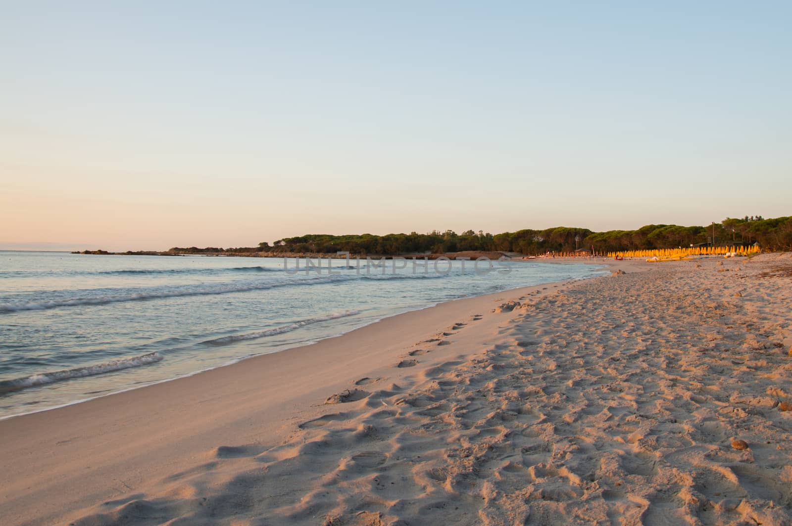 The beautiful beach of Cala Ginepro when the sun is rising in Sardinia next to Bidderosa, Italy