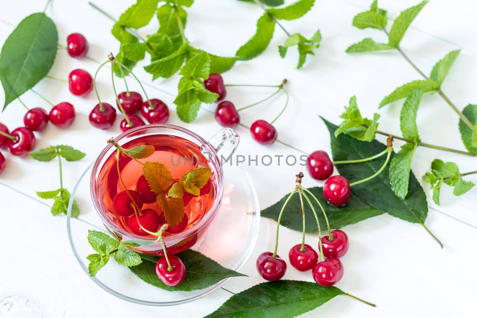 Fresh fruit cherry drink in transparent glass cup surrounded by  by ArtSvitlyna