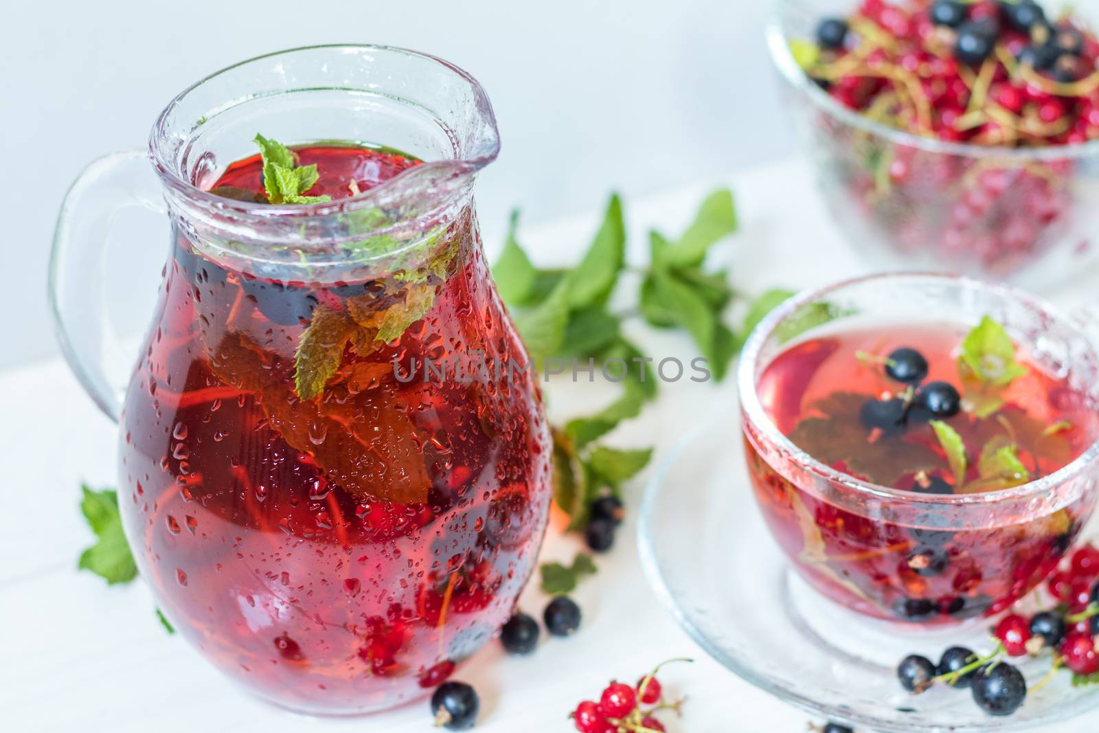Fruit drink in transparent glass carafe and cup by ArtSvitlyna