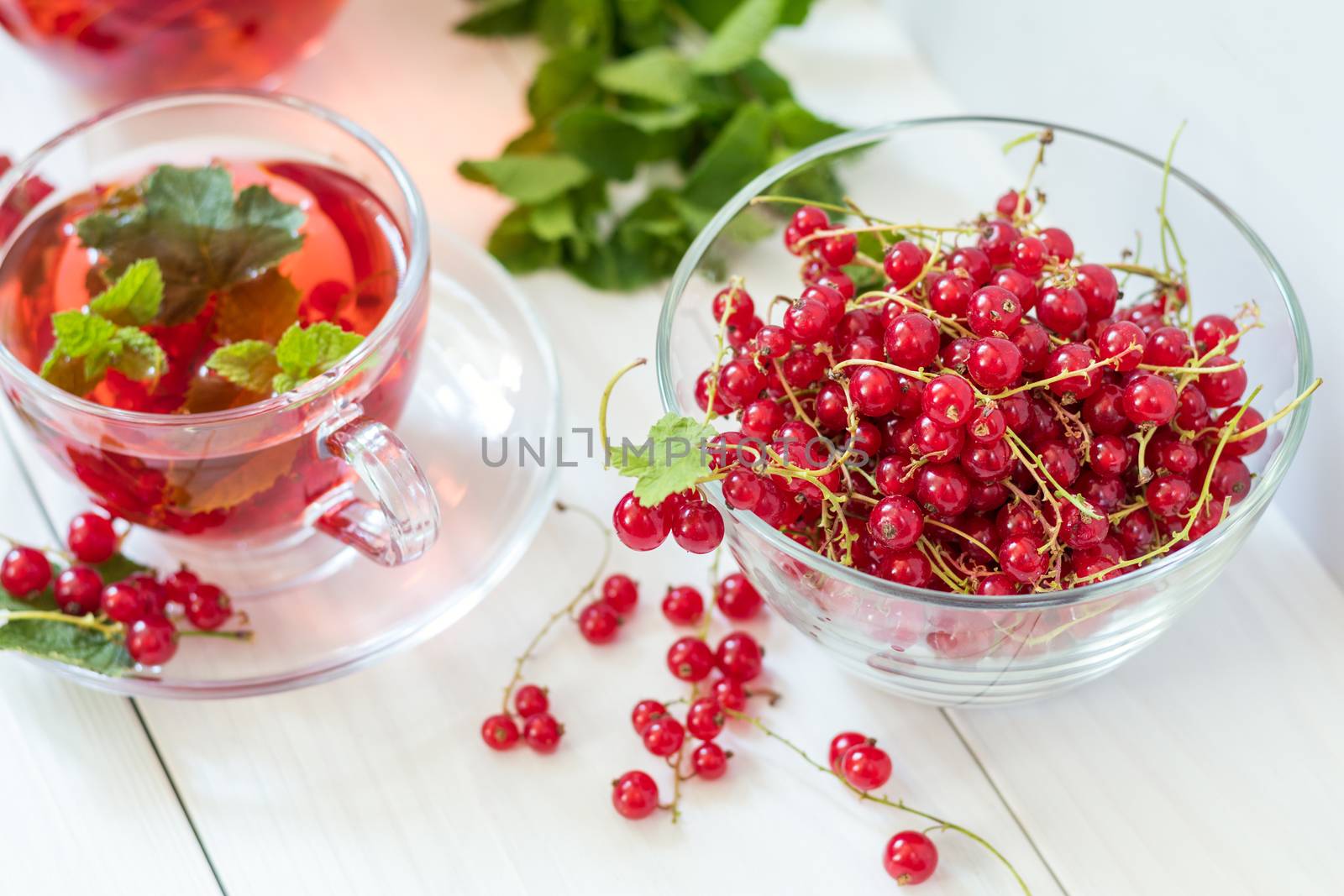 Fresh juicy redcurrant in clear glass vase. Shallow depth of field