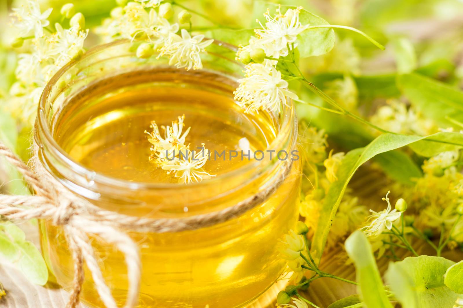 Honey in glass jars with white linden flowers by ArtSvitlyna