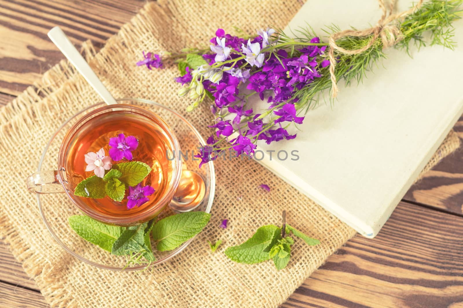 Glass cup of summer tea with herbs by ArtSvitlyna