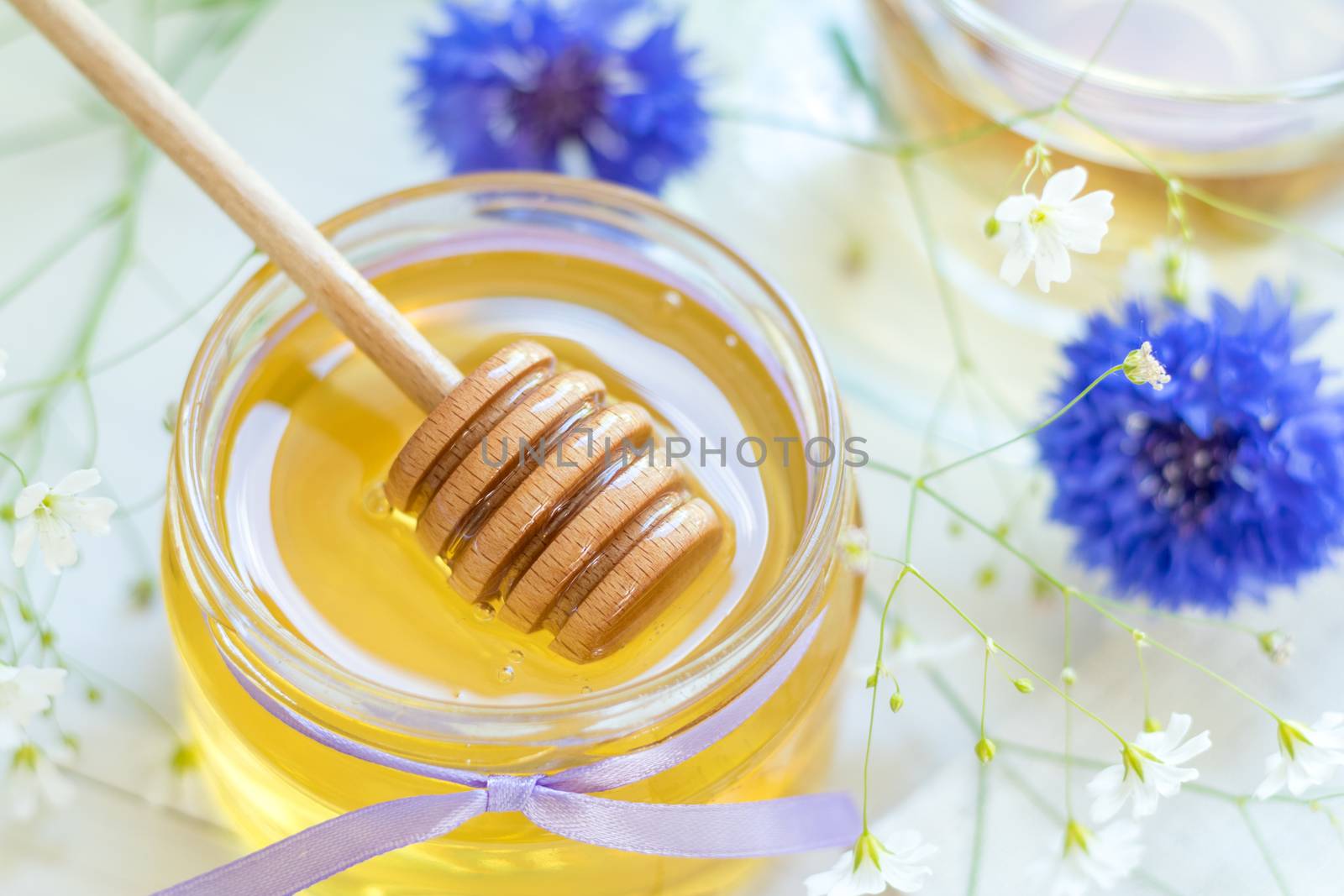 Honey in glass jars and cup of tea by ArtSvitlyna