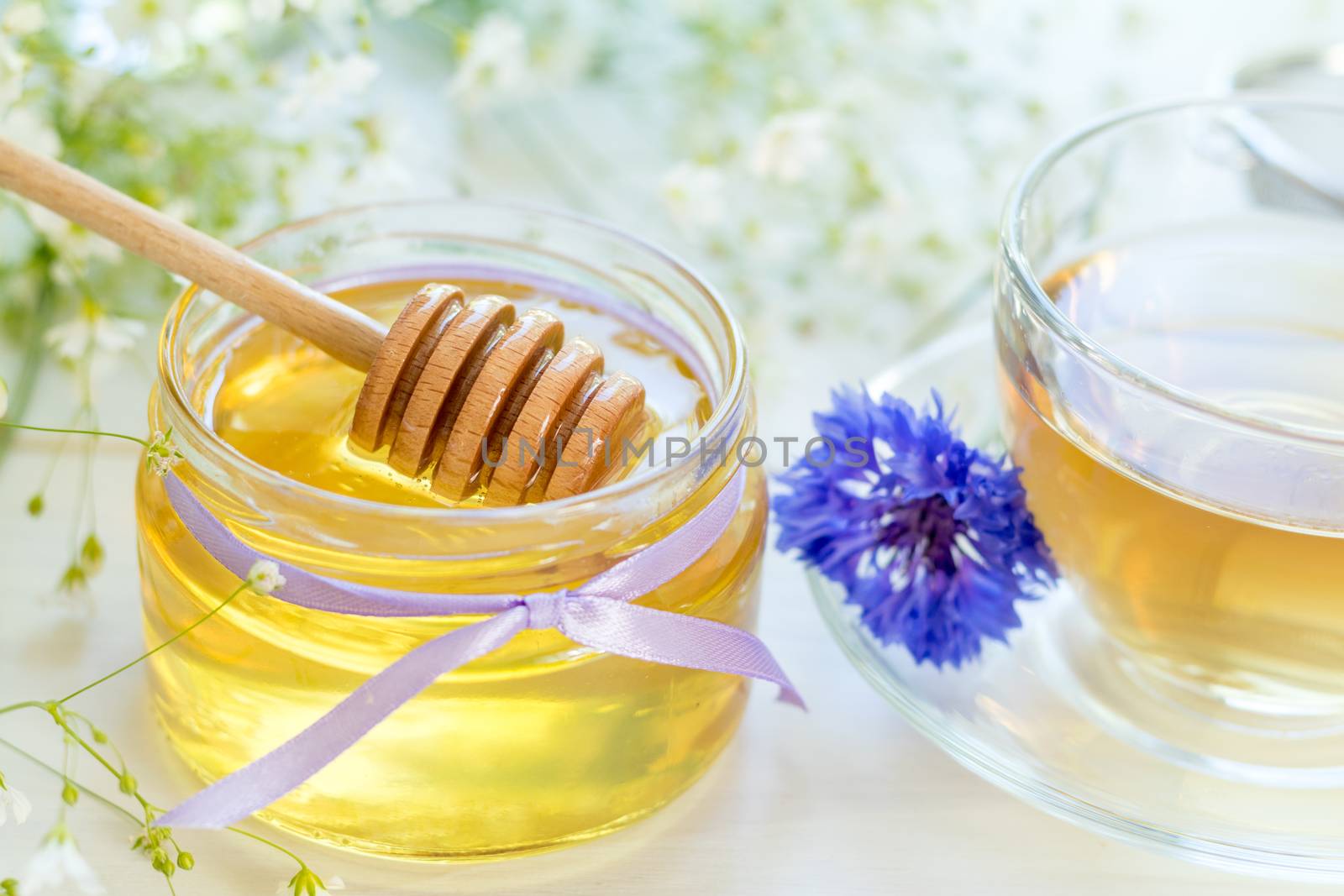 Honey in glass jars and cup of tea by ArtSvitlyna