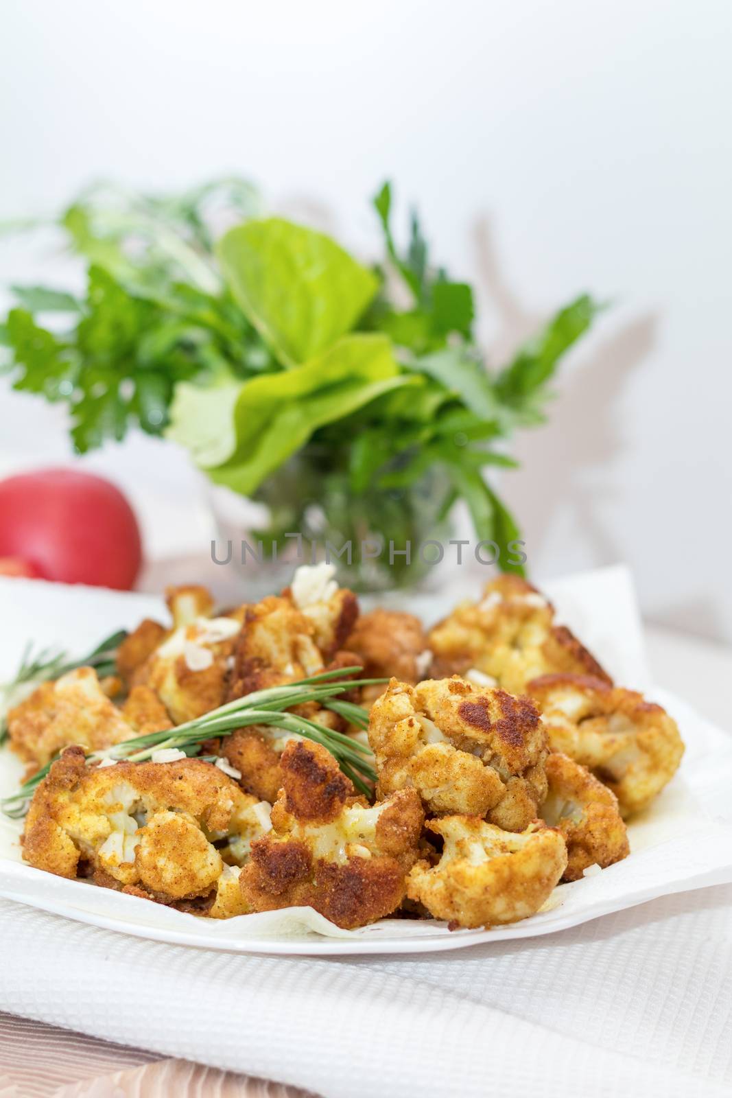 Fried cauliflower in batter on a white plate with white napkin.  by ArtSvitlyna