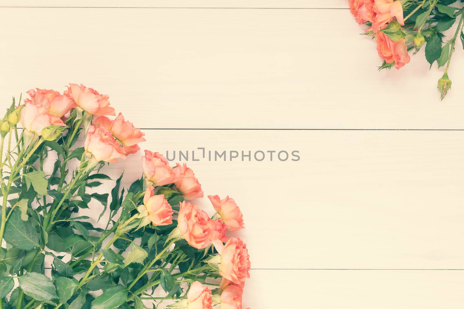 Pink orange roses bouquet over wooden table. Holidays easter, mothers day, valentine, wedding background with copy space. Top view.