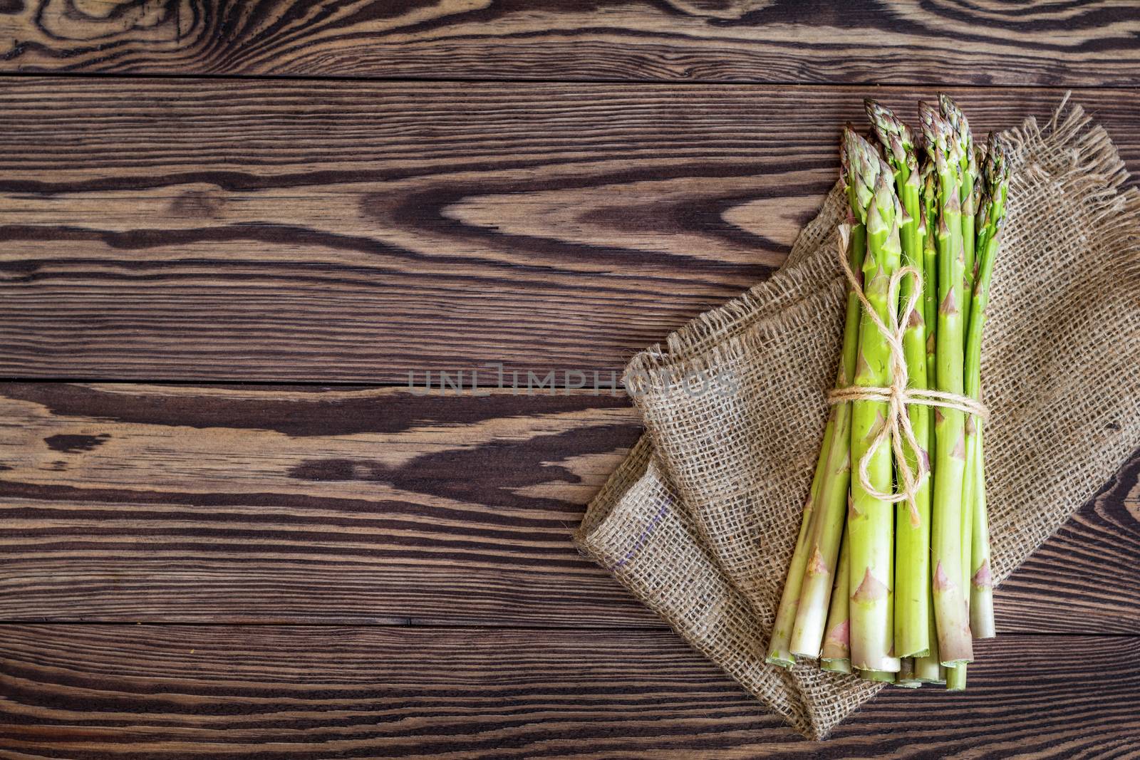 Bunch of fresh green asparagus spears on a rustic wooden table