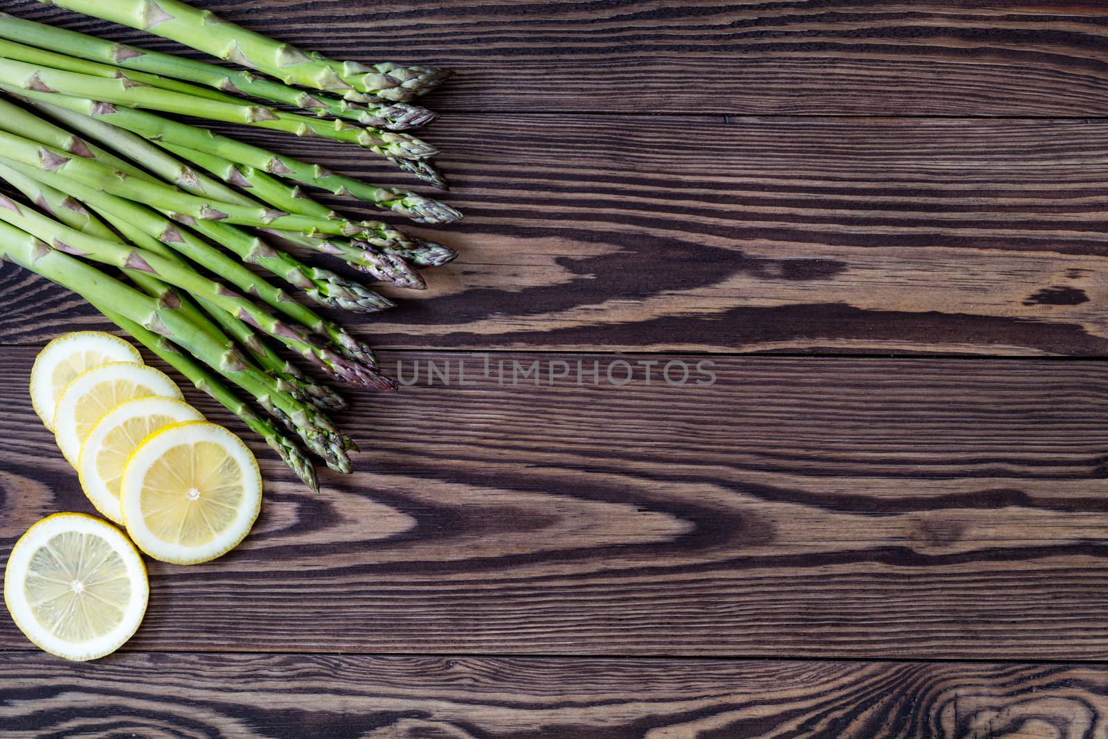 Fresh asparagus on wooden background by ArtSvitlyna