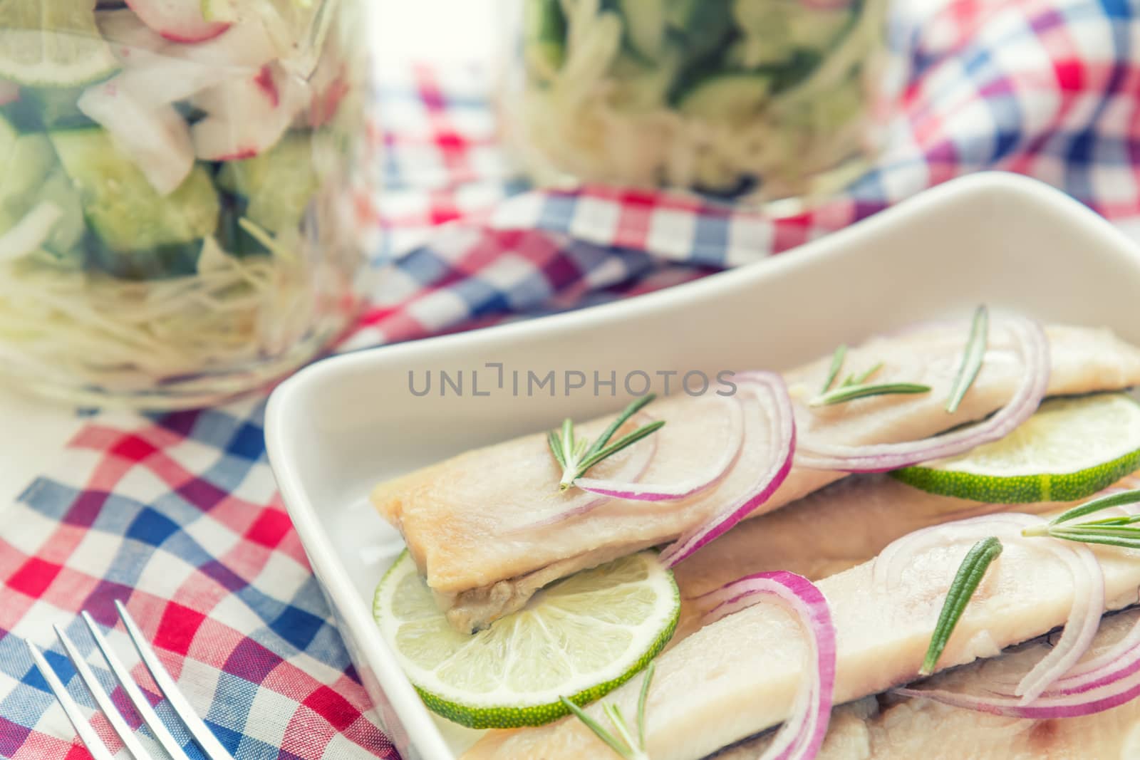 Sliced herring fillets, cut onion and lime by ArtSvitlyna