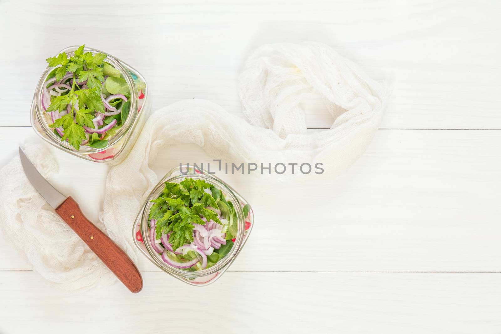 Homemade healthy salads with vegetables, onion, parsley and lettuce in jar. Toning. Selective focus.