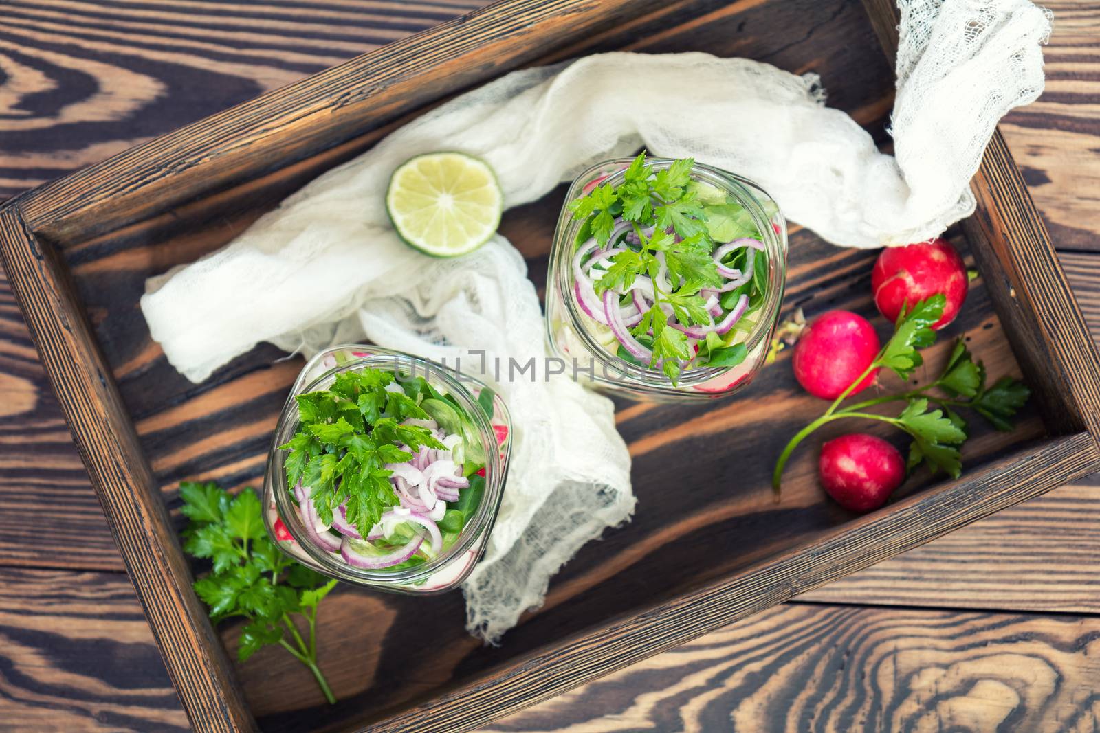 Homemade healthy salads with vegetables, onion, parsley and lettuce in jar. Toning. Selective focus.