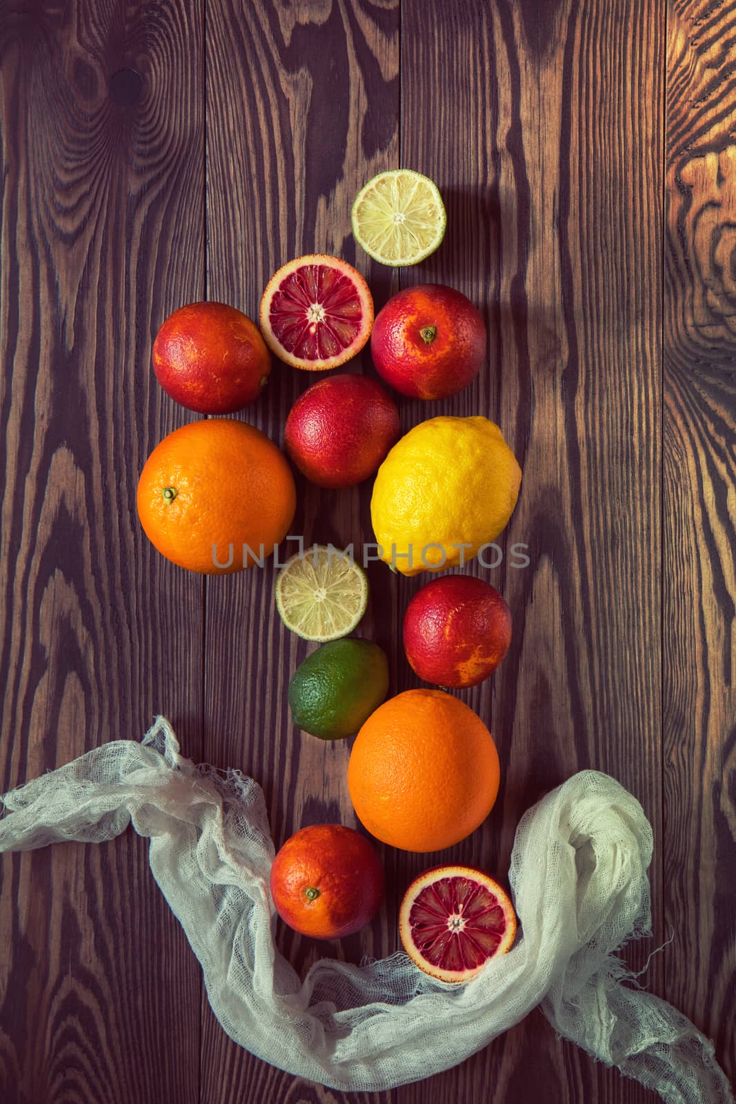 Citrus fruits over old dark wooden background. by ArtSvitlyna