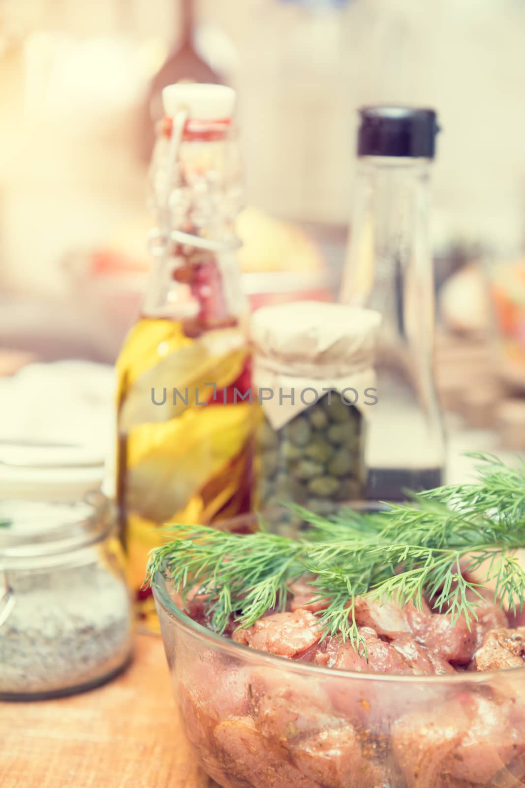 Raw pork neck meat cut in slices with marinated in glass bowl  in a modern kitchen. Shallow depth of field. Toned