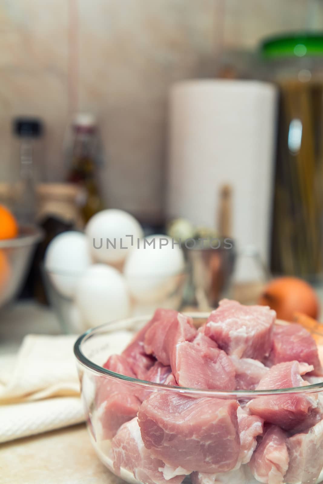 Raw pork neck meat cut in slices on glass bowl. Shallow depth of field. Toned.