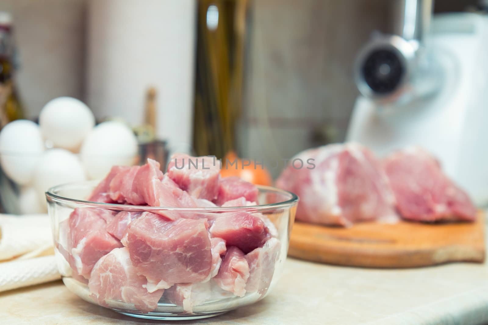 Raw pork neck meat cut in slices on glass bowl. Shallow depth of field. Toned.