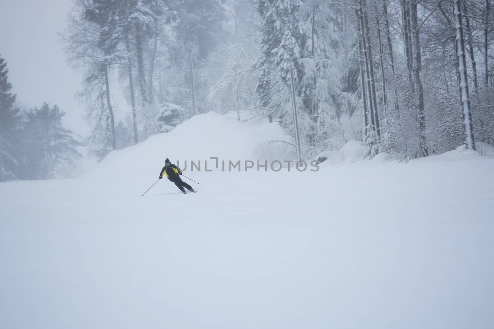 Skier on piste running downhill by destillat