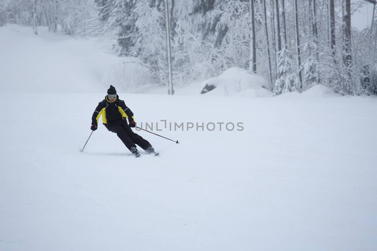 Skier on piste running downhill by destillat