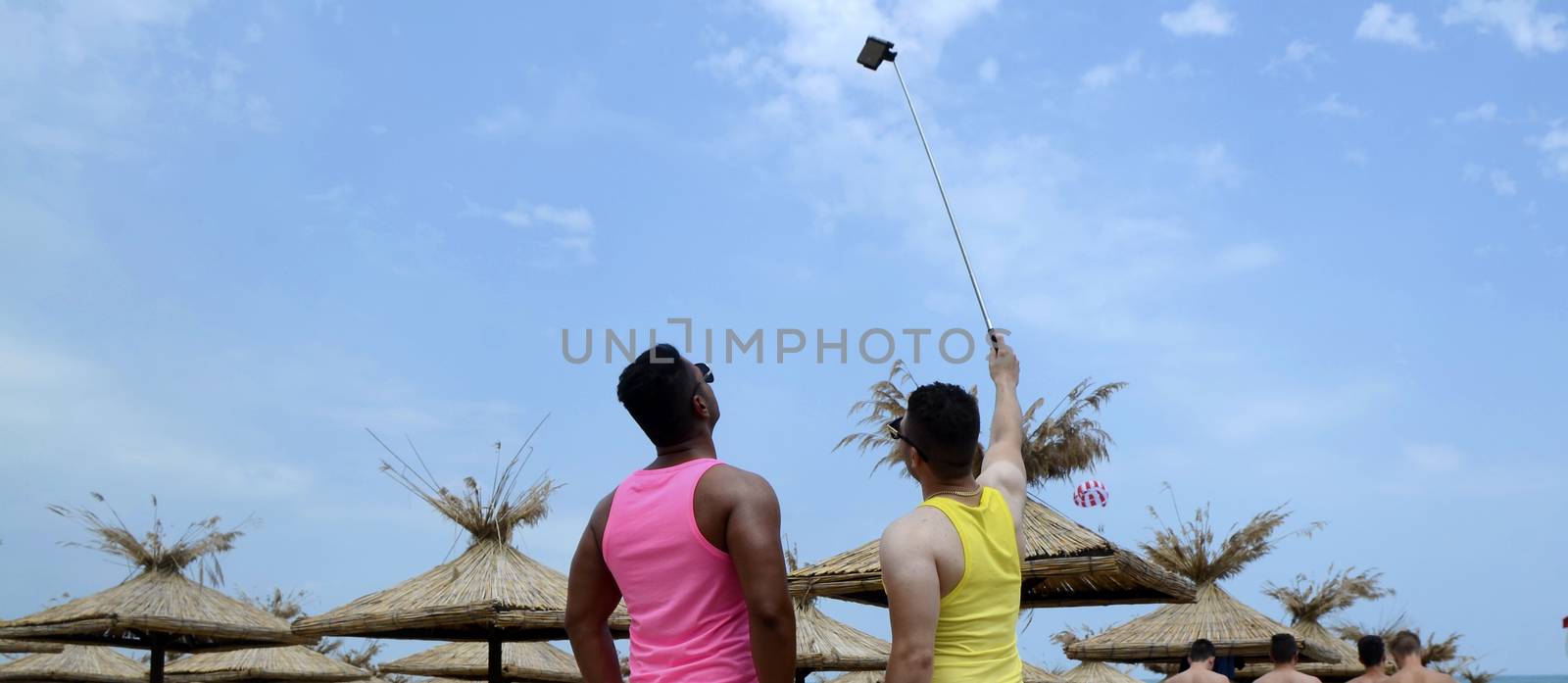 Two men making selfie photo on the beach