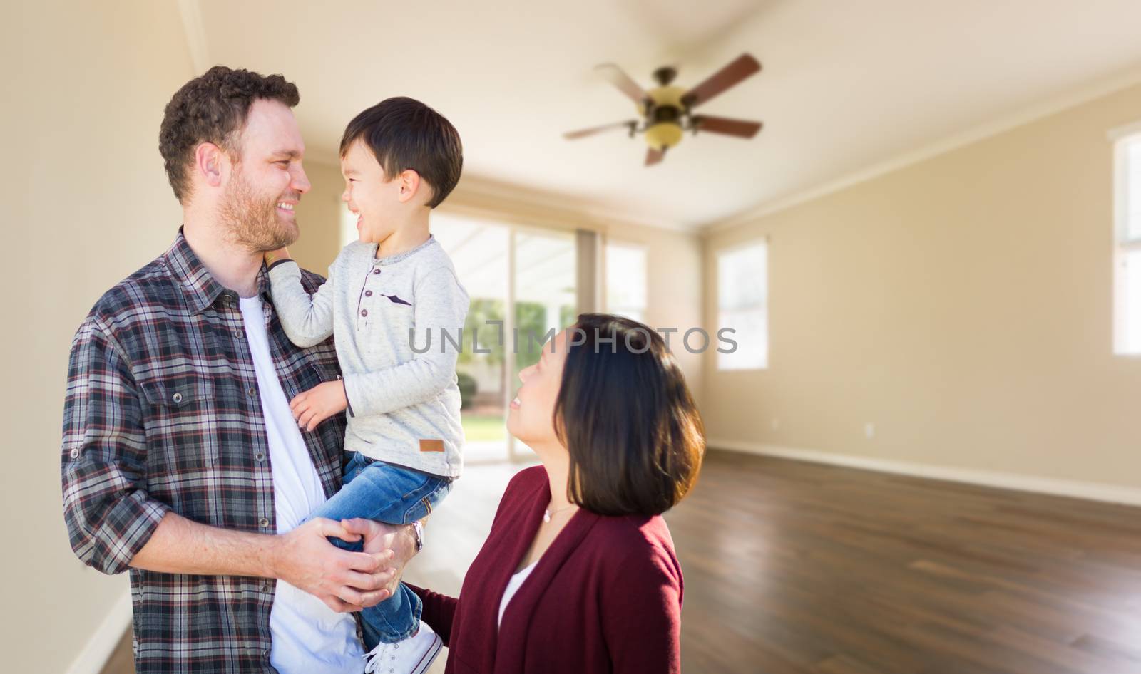 Young Mixed Race Caucasian and Chinese Family Inside Empty Room with Wood Floors.