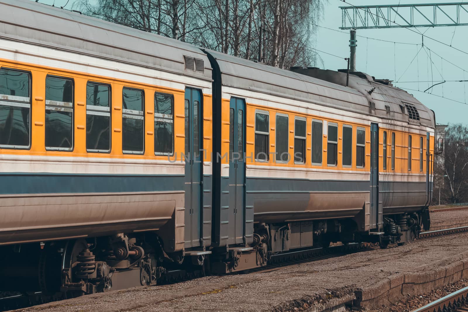 Old yellow passenger diesel train moving at the terminal