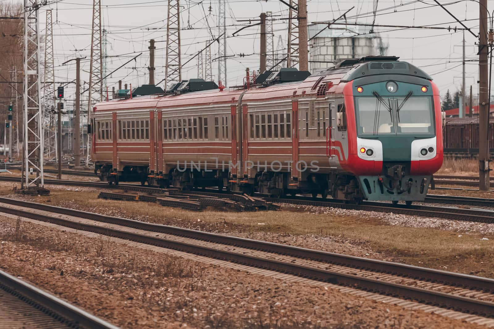 Red diesel passenger train driving at the old terminal