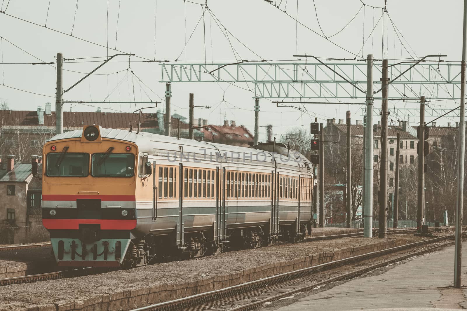 Old yellow passenger diesel train moving at the terminal